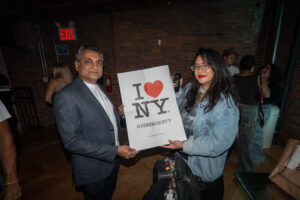 Iconic Magazines owner Hemal Sheth and an attendee holding an I LOVE NY and Highsnobiety poster.