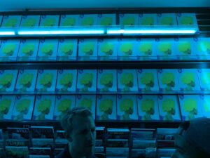 Copies of AriZona 99¢ Magazine stacked wall to wall under blue event lighting