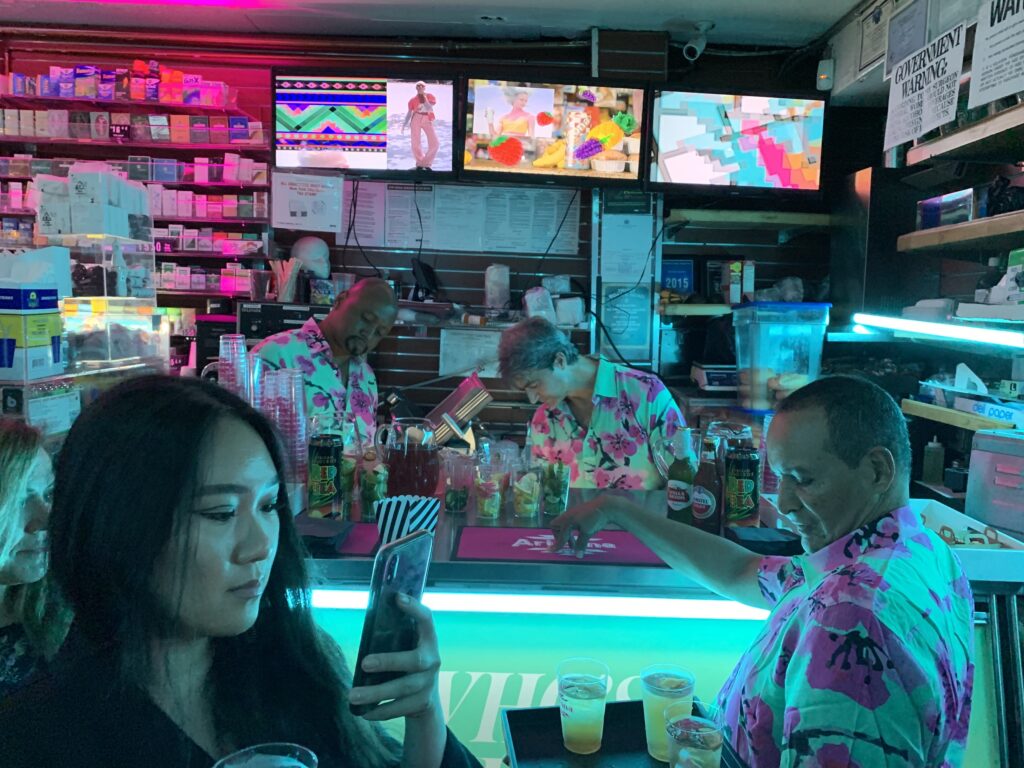 Bartenders in floral shirts pouring AriZona cocktails behind the counter