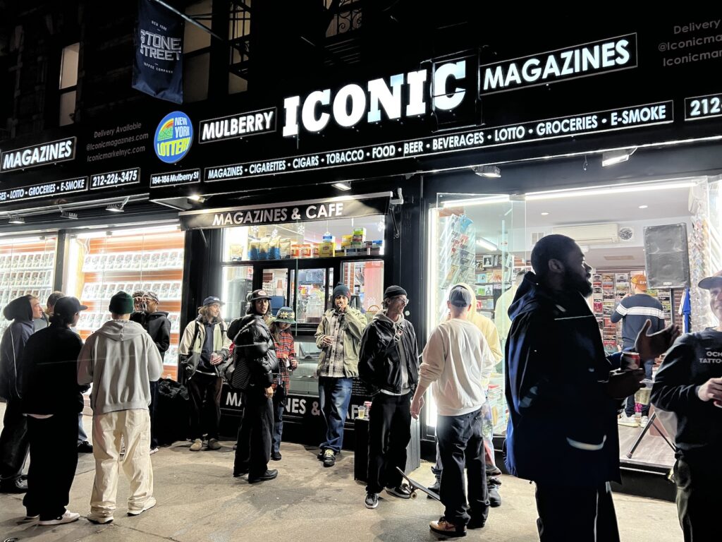 people outside iconic magazine store at night