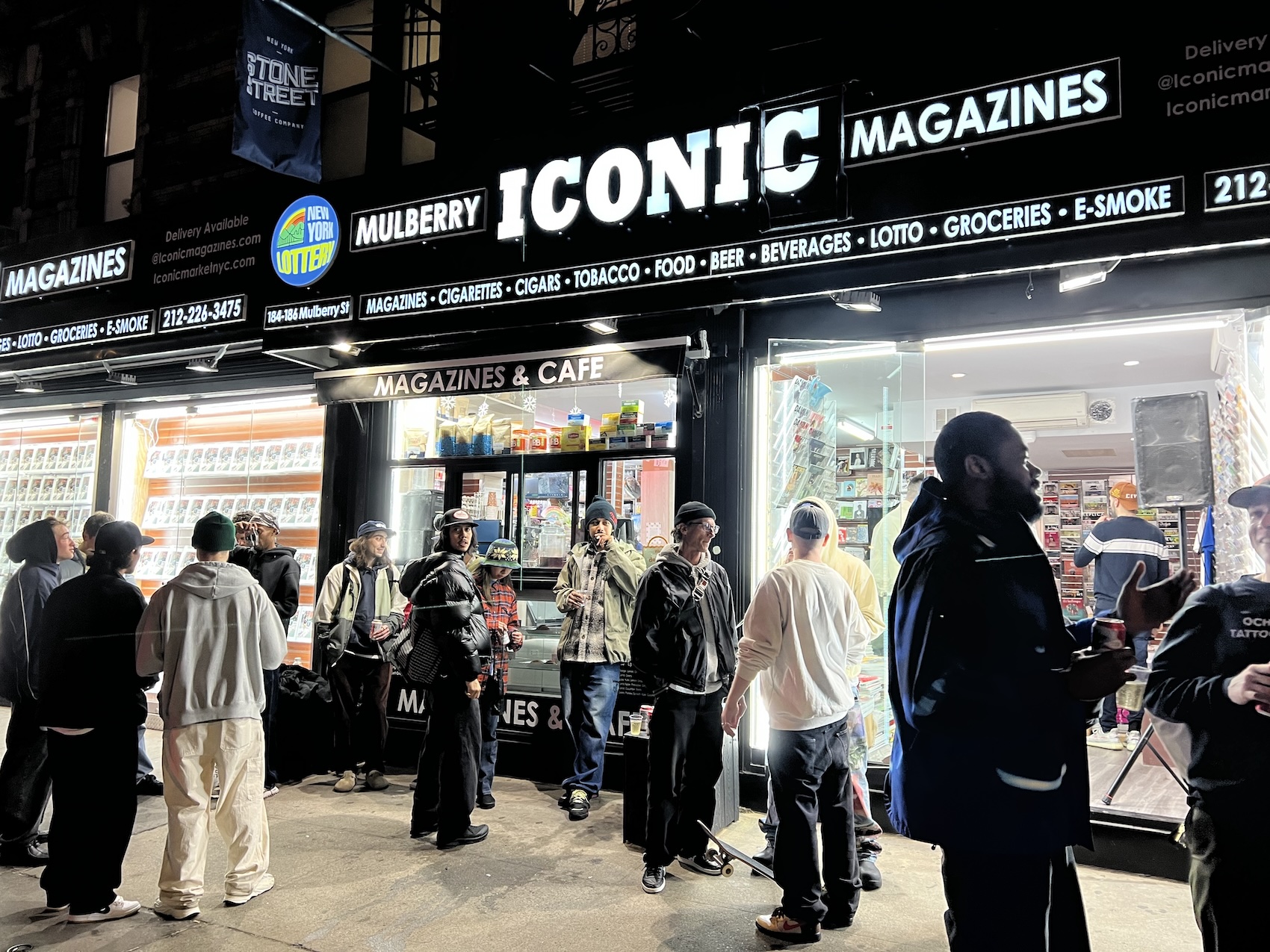 people outside iconic magazine store at night