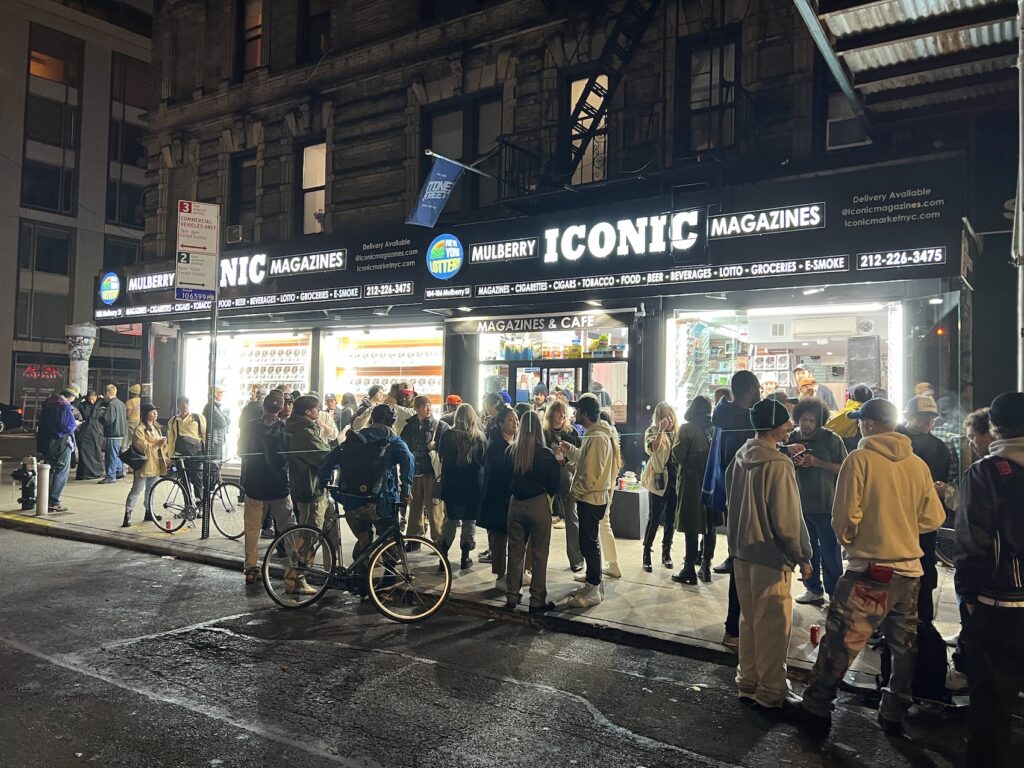 people outside iconic magazine store at night