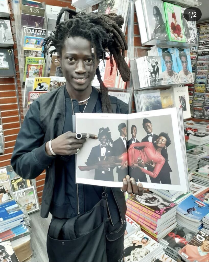Talent featured in Volume 0: SEEN holding open the debut publication inside the magazine shop.
