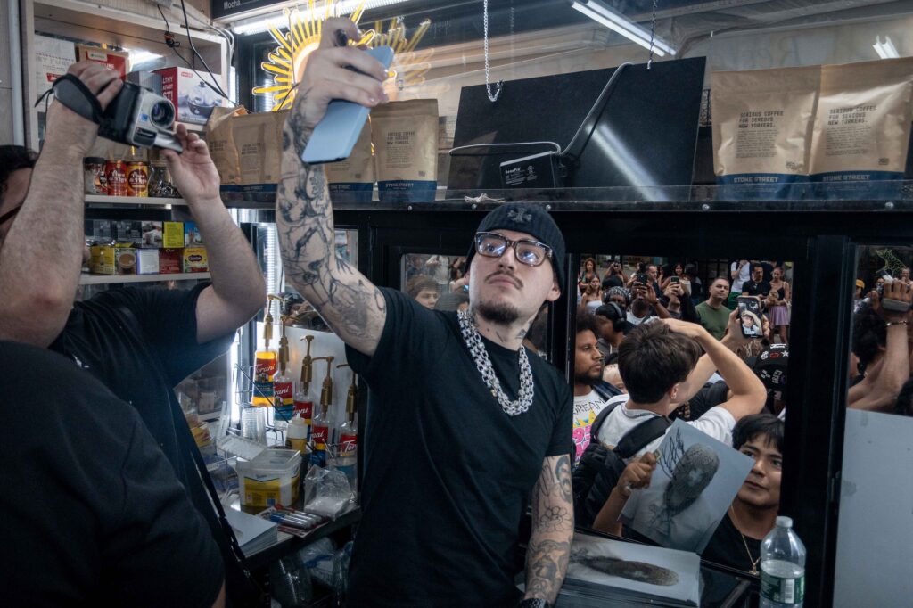 Yeat at the café window as fans film the Grailed zine drop at Iconic Magazines, Mulberry Street