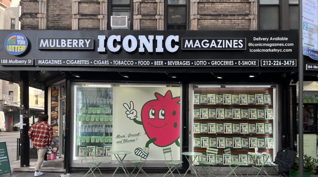Bloom Nutrition New York pop-up takeover at Iconic Magazines, Mulberry Street, with a strawberry mascot and product-filled windows.